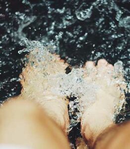 Two bare feet surrounded by splashing water.
