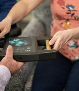 Two female hands holding a device during bio-energetic testing